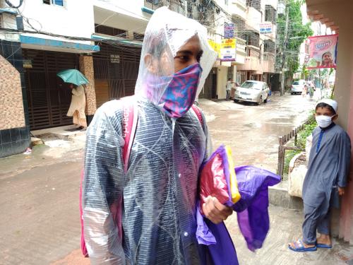 হঠাৎ বৃষ্টিতে যাদের কাছে ছাতা নেই তাদের কাছে ফেরি করে রেইন কোট বিক্রি করছেন এই ফেরিওয়ালা